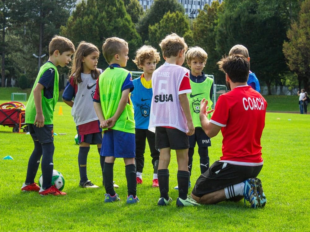 SUSA coach training a group of young players on the pitch