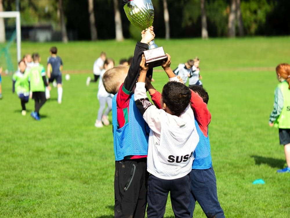 SUSA players lifting a trophy on the pitch